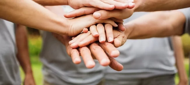 A group stacking their hands together